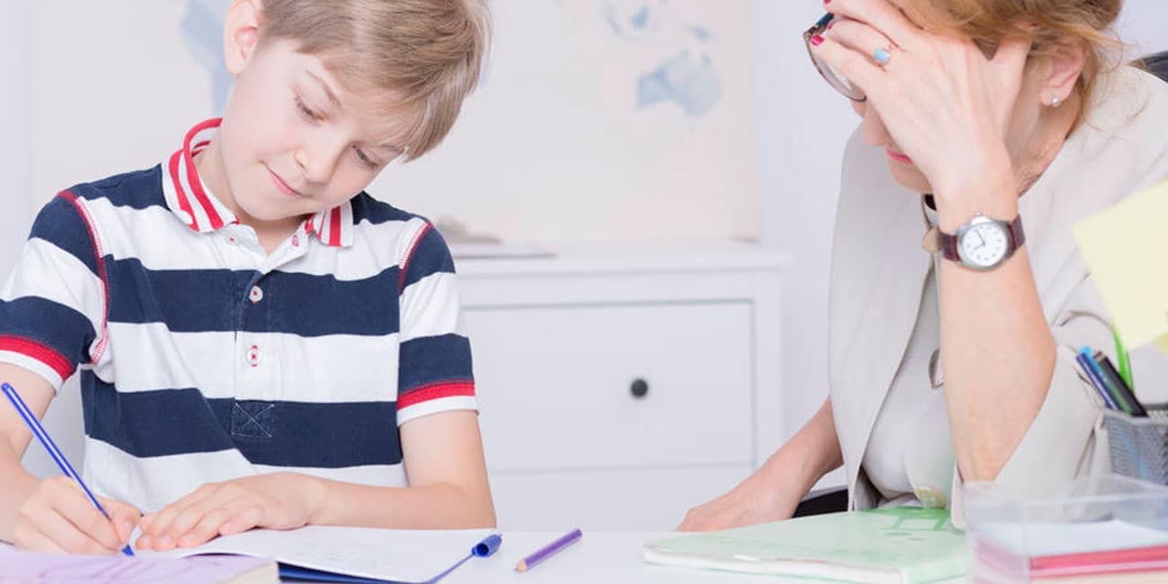 Young boy writing for a tutor