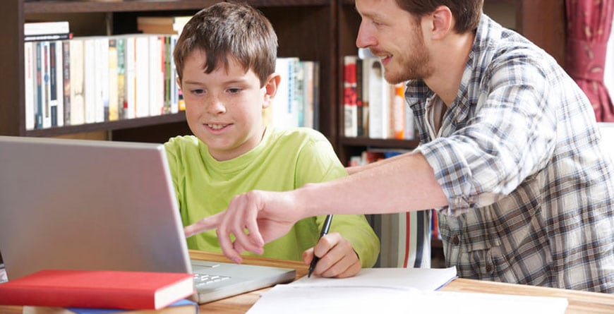 Father helping son on computer